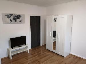 a white room with a mirror and a television at Lüdenscheid-Ferienwohnung de Betzler Weh29-100 in Lüdenscheid