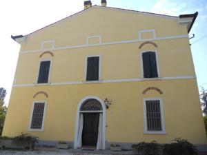 een geel gebouw met zwarte deuren en ramen bij Agriturismo Boaria Bassa in Castel dʼArio