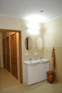 ein Badezimmer mit einem weißen Waschbecken und einem Spiegel in der Unterkunft Tonal in Mukatschewo
