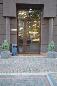 a glass door of a building with two plants in front at Tonal in Mukacheve