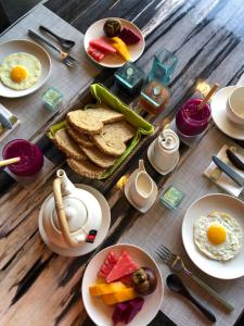 a wooden table topped with plates of breakfast foods at Rouge - Private Villa Condense in Ubud +23 photos