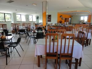 uma sala de jantar com mesas e cadeiras num restaurante em Hotel Canto Da Praia em São Luís