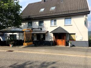 a large white building with an orange door at Hotel garni Zum Adenauer Forst in Wimbach