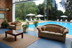 a living room with two couches and a pool at Solanas Termas de Dayman in Termas del Daymán