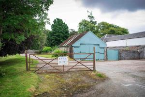 a gate with a sign in front of a barn at Coachmans Bothy - 50m from the beach in Port Appin