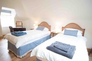 a bedroom with two beds with towels on them at Coachmans Bothy - 50m from the beach in Port Appin