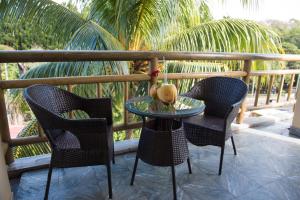 two chairs and a glass table on a patio at 3Ds International Tourist Home in Mahébourg