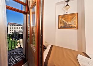 a bedroom with a balcony with a bed and a window at Nusretbey Hotel in Istanbul