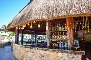 a bar with a straw roof with bottles of alcohol at Reef Yucatán All Inclusive & Convention Center in Telchac Puerto