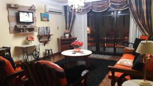 - un salon avec une table et une télévision dans l'établissement apto centro de gramado, à Gramado