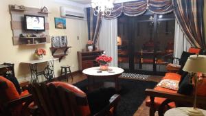 a living room with a table and a tv at apto centro de gramado in Gramado
