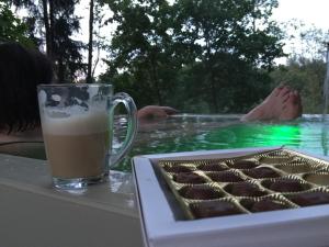 a glass of coffee and a tray of cupcakes in a swimming pool at Economy rooms for 2-4 people in Anykščiai