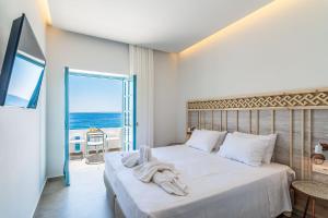 a bedroom with a bed with a view of the ocean at Livikon by the Sea in Hora Sfakion