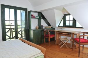 a bedroom with a bed and a desk and chairs at Vineyard Cottage Zdolsek in Šmarje pri Jelšah