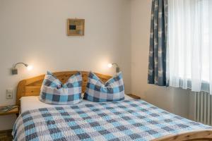 una camera con un letto con due cuscini blu e bianchi di Schelterhof a Wunsiedel