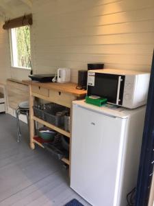 eine Küche mit einer Mikrowelle auf dem Kühlschrank in der Unterkunft Pipowagen Jasmijn bij Pipowagen en kampeerhoeve s Gravenhof in Netterden