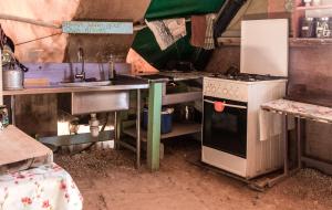 a dirty kitchen with a stove and a refrigerator at Silent Arrow in Mitzpe Ramon
