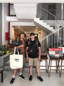 two men standing next to each other in a building at Lem's Apartment & Coffee in Da Nang