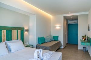 a hotel room with two beds and a couch at Samaria by the Sea in Hora Sfakion