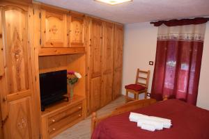 a bedroom with a bed and a flat screen tv at Chez Elida in Saint-Christophe