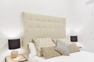 1 dormitorio con 1 cama blanca con almohadas y lámparas en LEEWAYS APARTMENT XX in GRAN VÍA en Madrid