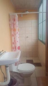 a bathroom with a toilet and a sink at Hotel Latino in San José