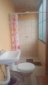 uma casa de banho com um WC e um lavatório em Hotel Latino em San José