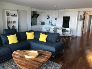 Una sala de estar con un sofá azul y una mesa. en appartement vue mer, en Cannes 21 fotos más