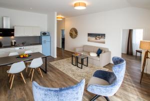 ein Wohnzimmer mit einem Sofa, einem Tisch und Stühlen in der Unterkunft Appartements an der Golfanlage in Warnemünde