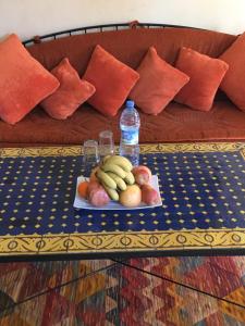 una mesa con una bandeja de fruta y una botella de agua en Zina, en Marrakech