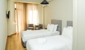 a hotel room with two beds with white sheets at Teryan Pushkin Apart Hotel in Yerevan