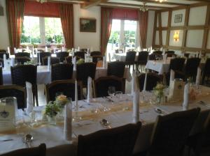 a room filled with tables and chairs with white tablecloths at Brammers Landhotel Zum Wietzetal in Wietzendorf