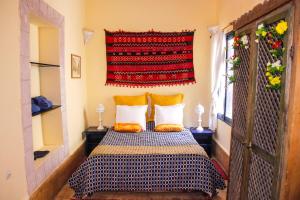 a bedroom with a bed with two pillows and a window at Riad Lunetoile in Essaouira