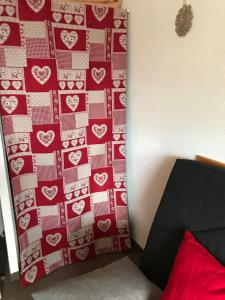 a bedroom with a red wall with hearts on it at STUDIO MONTAGNE 4 PERSONNES LE SEIGNUS BAS in Allos