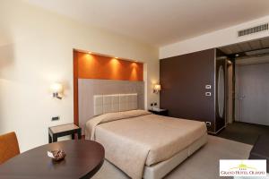una camera d'albergo con letto e tavolo di Grand Hotel Olimpo ad Alberobello