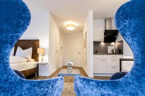 um quarto com uma cama e duas cadeiras azuis em Appartements an der Golfanlage em Warnemünde