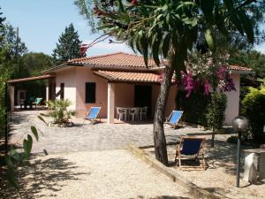 a house with chairs and a table in front of it at Casa Matilde in Capoliveri