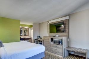 Habitación de hotel con cama y TV de pantalla plana. en Seabreeze Inn - Fort Walton, en Fort Walton Beach