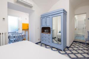 a bedroom with a blue dresser and a mirror at Villa Elisa Holiday Home in Sorrento
