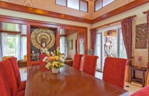 a dining room with a table and red chairs at Thai style villa with very beautiful private pool in Kamala Beach