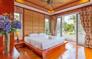 a bedroom with a bed in a room with windows at Thai style villa with very beautiful private pool in Kamala Beach +48 photos