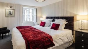 a bedroom with a large bed with red pillows at The Orchard House in Rothbury