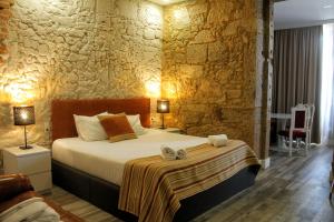 una camera da letto con un letto e un muro di pietra di Art'Otel Barcelos a Barcelos