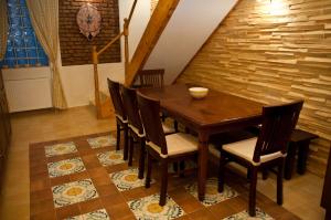 jadalnia z drewnianym stołem i krzesłami w obiekcie Arina Apartments w Braszowie