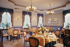 a dining room with tables and chairs and chandeliers at Hotel Aleksander in Włocławek