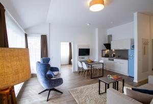 uma sala de estar com uma cadeira azul e uma mesa em Appartements an der Golfanlage em Warnemünde