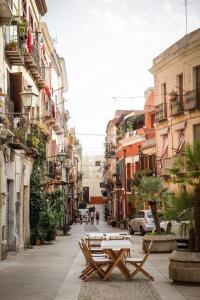 two picnic tables on a street with buildings at Villanova Sweet Home in Cagliari