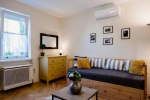 a living room with a couch and a window at Viola Family Apartman free parking in Pécs
