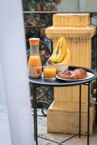 a table with a plate of fruit and a bottle of orange juice at Deák20 Residence in Szeged