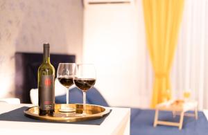 a bottle of wine and two glasses on a table at Jacuzzi studio apartman Mare's in Zagreb